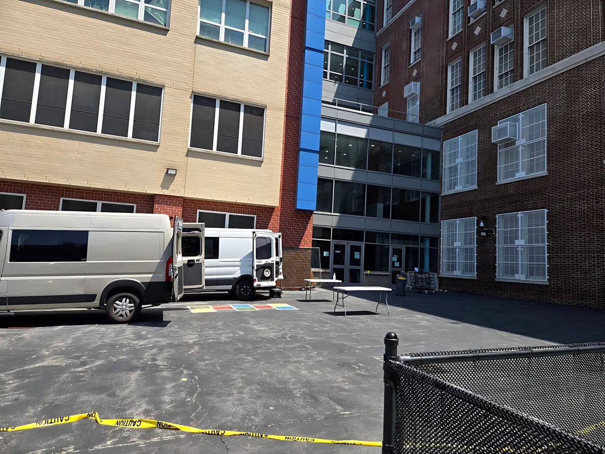 Work vans parked in a school courtyard on the first day of a job